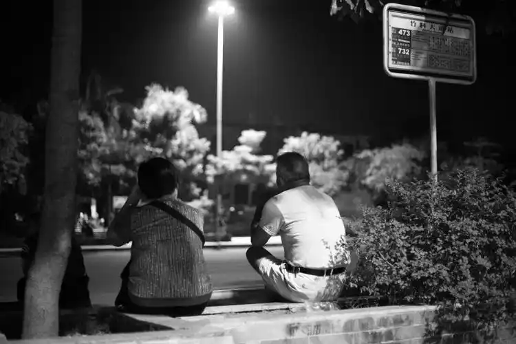 小城夏天的夜晚,公交站旁乘凉的夫妻