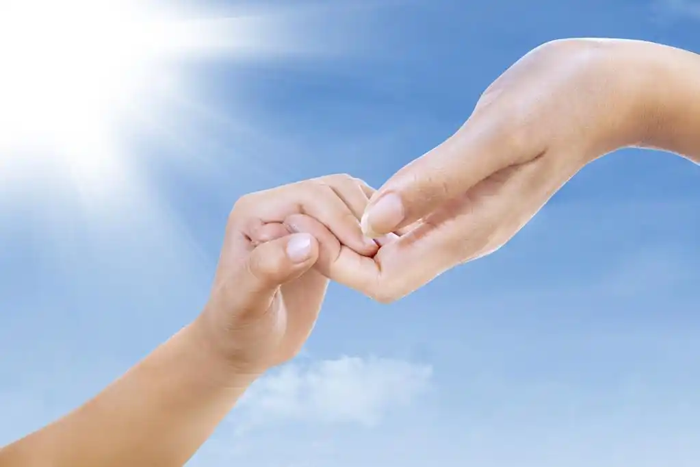 伸出援手,手势 (妈妈和孩子) 的两只手在蓝蓝的天空下,手牵着手