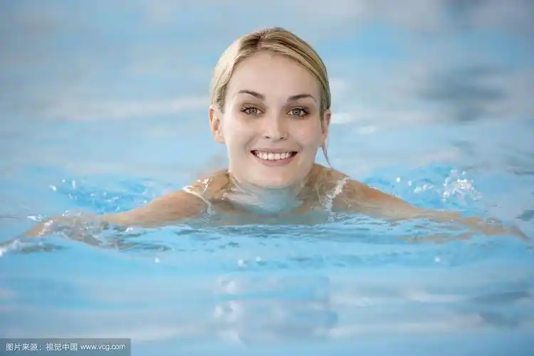 年轻女子在游泳池游泳