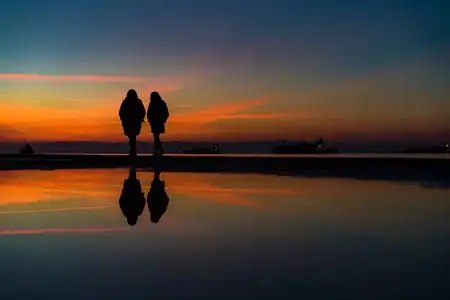 两个女人剪影在海边漫步的倒影, 基督徒照片