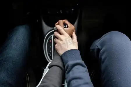 特写情侣开车时手牵着手脚车舱