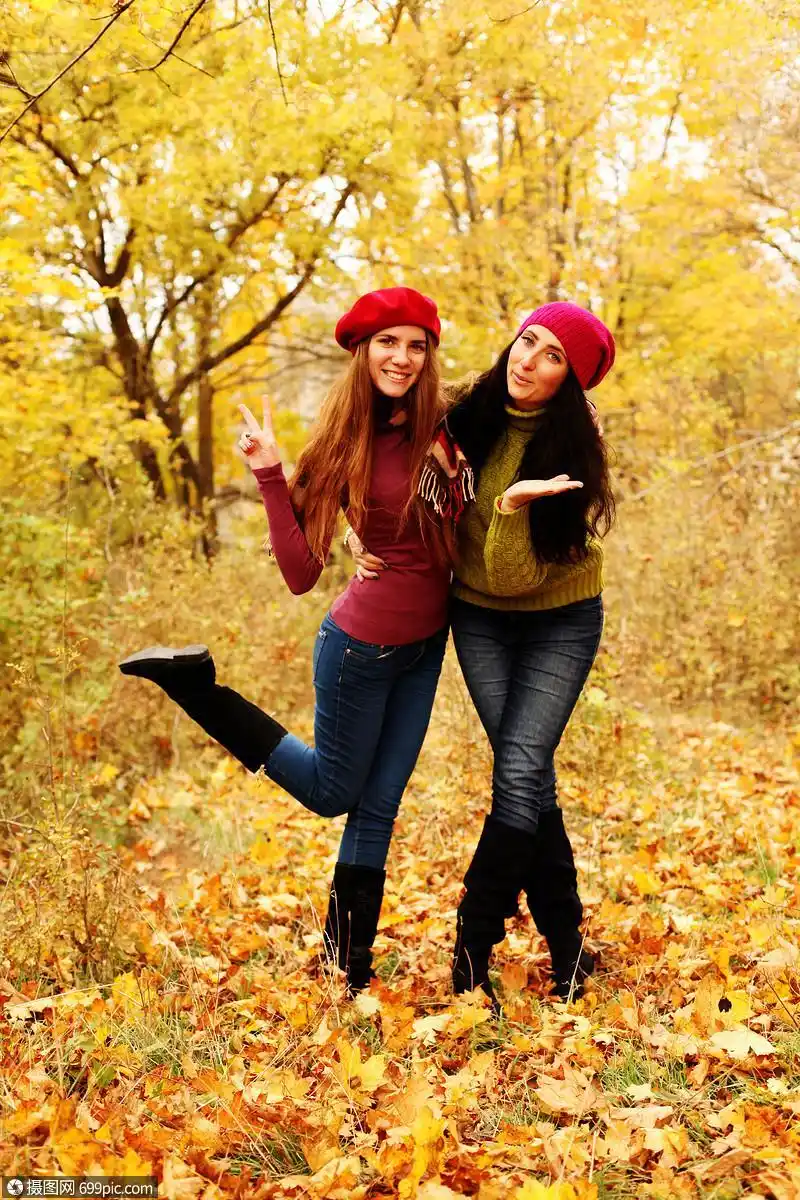 两个女孩朋友秋天的森林里摆姿势