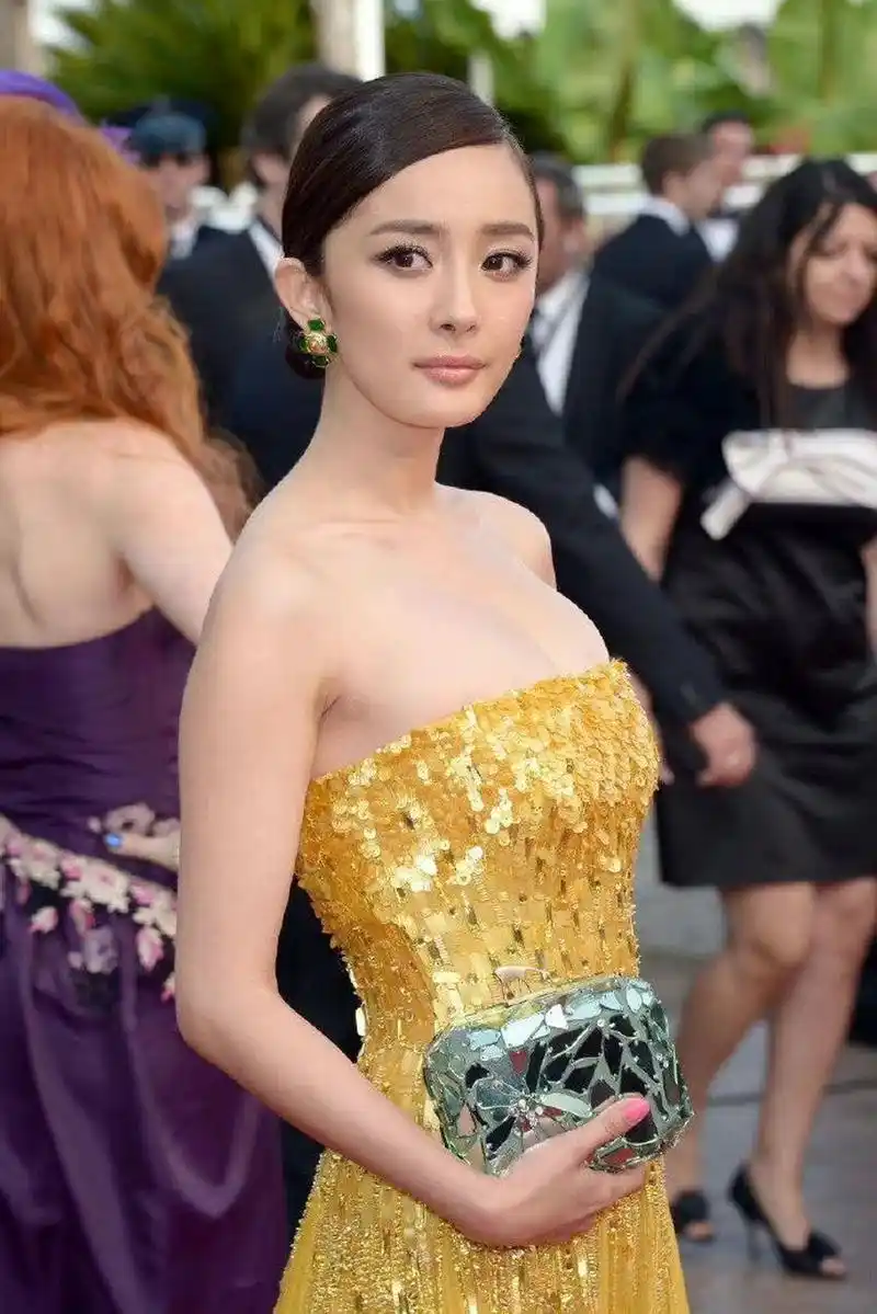 杨幂身穿露肩抹胸礼服,女人味爆棚  在照片中,杨幂身穿一件亮黄色的抹