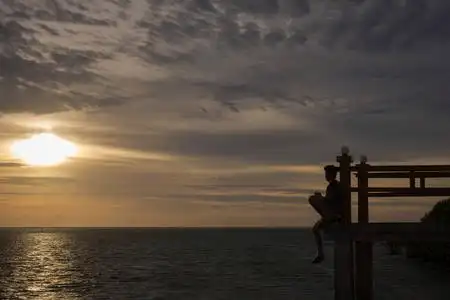 印度尼西亚皇家岛云岸由破船的轮廓与岸日出在夕阳的映衬下,海滩上的