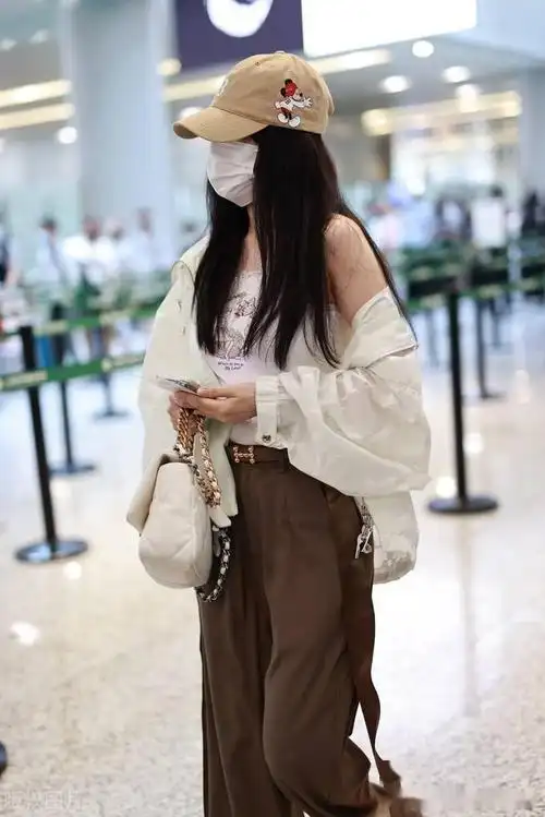 街拍:李小璐穿白色吊带背心宽松长裤大头皮靴个性随意_机场