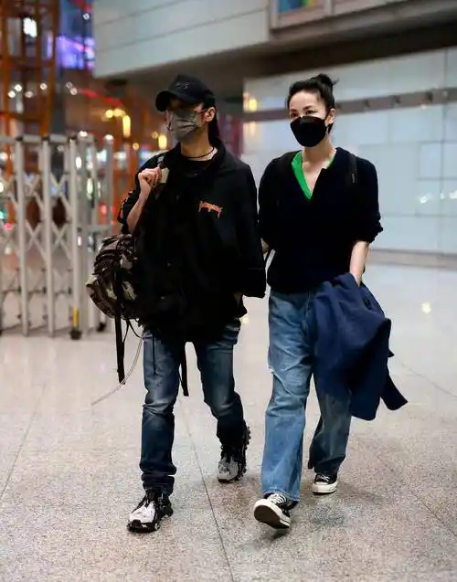 王菲和谢霆锋挽着手走向机场,休闲装扮简单又接地气,扎着丸子头好清爽