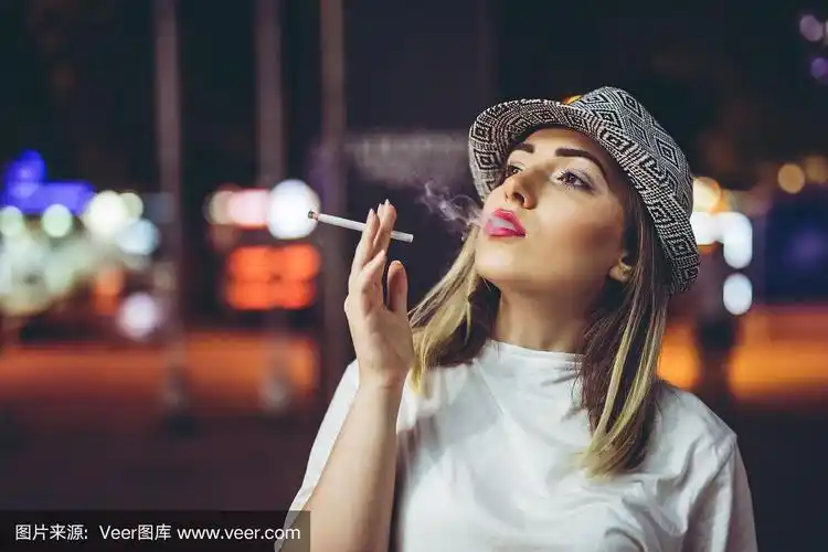 年轻的白人女孩在街上抽烟