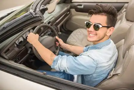 穿着墨镜的帅哥开车乘出租车看着摄图片