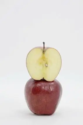 近拍一个苹果上放着切开的一半苹果