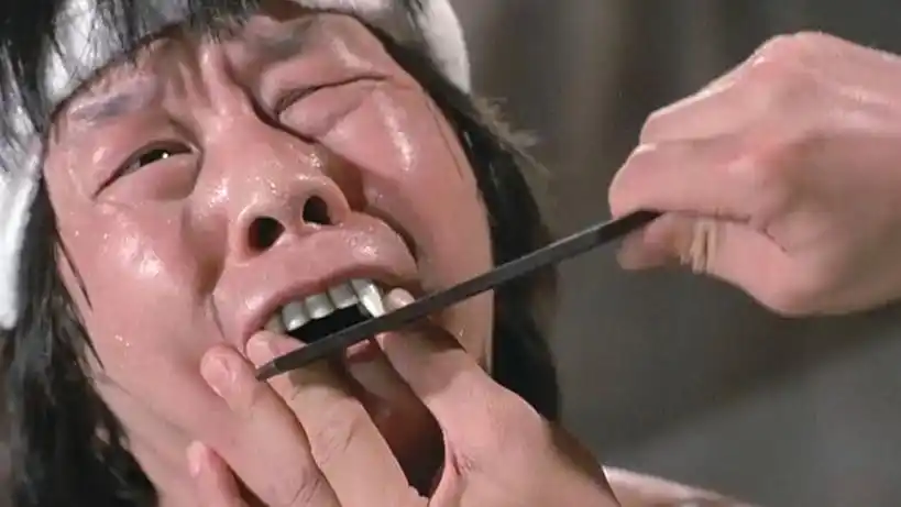 文才被僵尸抓伤,为了防止他咬人,秋生拿锉刀帮他磨牙