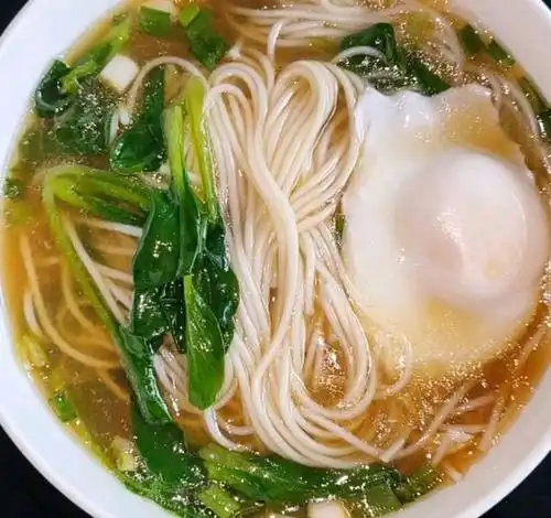 开始冒泡时打入一个鸡蛋,鸡蛋定型,并且锅中水开之后再放面条,水开