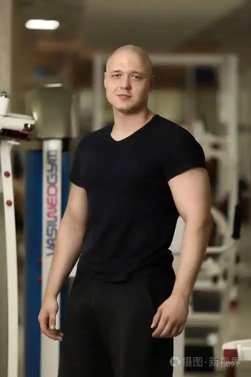 帅气的健美运动员拥有理想的身材,教练后在镜头前摆姿势