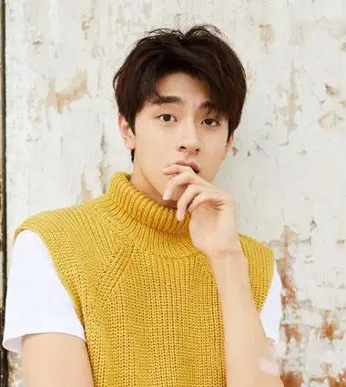 有比较强的空气感的男生二八分韩式烫短发发型,将额头上的发丝梳成