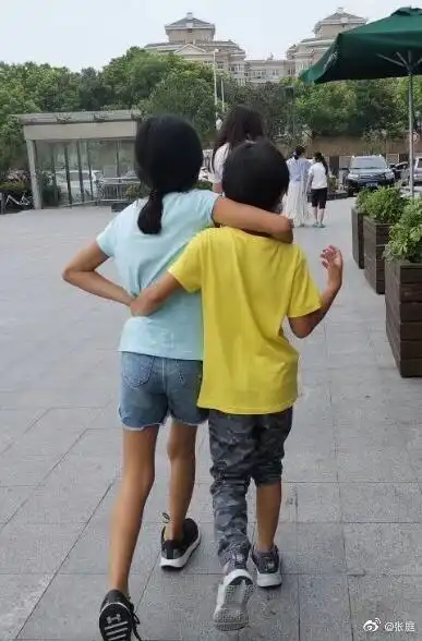 张庭晒儿女背影照感慨子女教育姐弟俩勾肩搭背并排走十分有爱