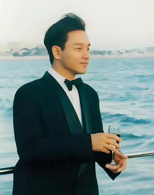 张国荣穿着黑色西装,海边清爽造型,帅气文雅有气质
