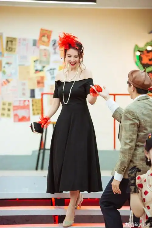 蔡少芬穿黑色抹胸连衣裙秀香肩 戴红色羽毛礼帽典雅复古