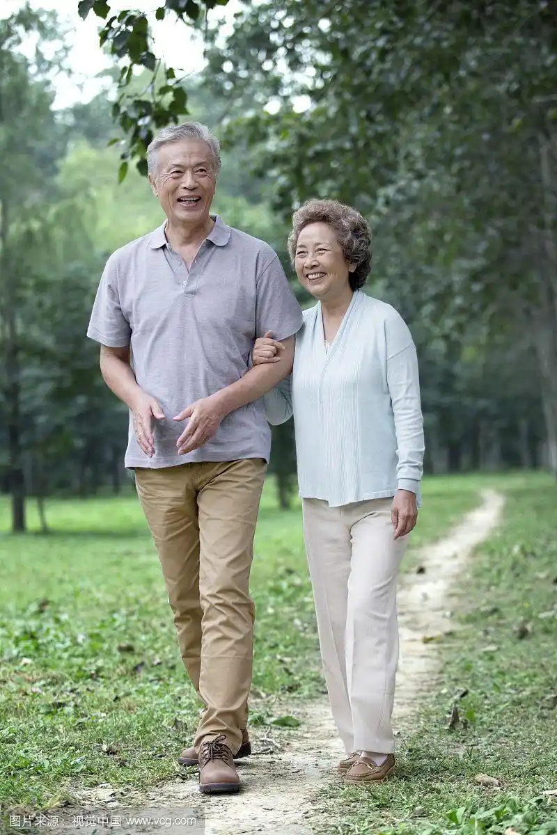 在公园散步的恩爱老夫妻