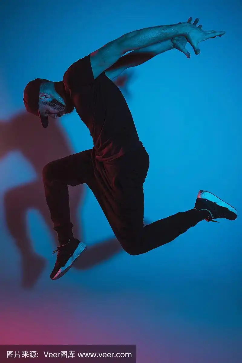 一个街舞男霹雳舞的剪影在多彩的背景上跳舞