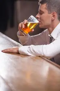 一个孤独的年轻人独自在酒吧喝酒.照片