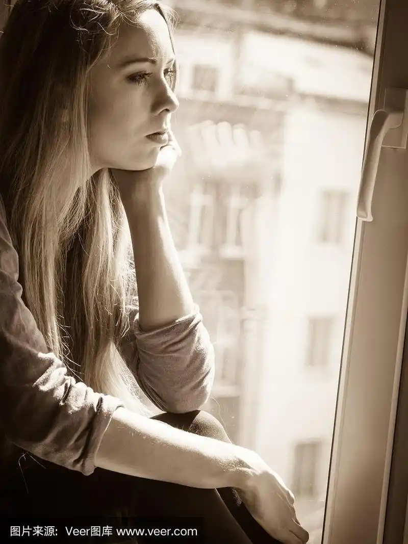 悲伤沮丧的少女坐在窗台上