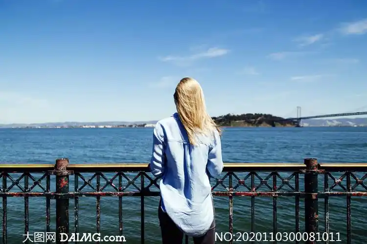 站在海边看海景的金发美女摄影图片