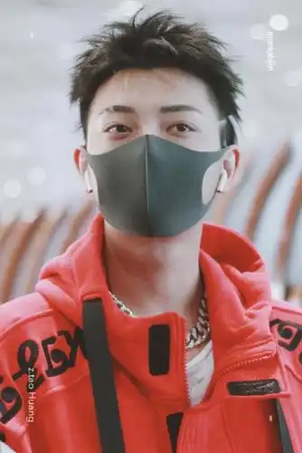 黄子韬穿红色连帽卫衣现身机场,戴着黑色口罩遮面