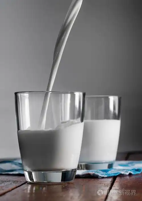 杯奶牛的牛奶在桌子上照片-正版商用图片1be647-摄图新视界