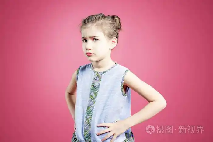 撅嘴愤怒的冒犯了粉红背景的女孩