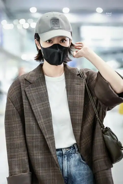 张小斐机场穿搭,复古格纹廓形西装搭配白t牛仔裤与棒球帽,休闲酷飒