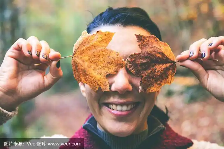 用树叶遮住脸的女人