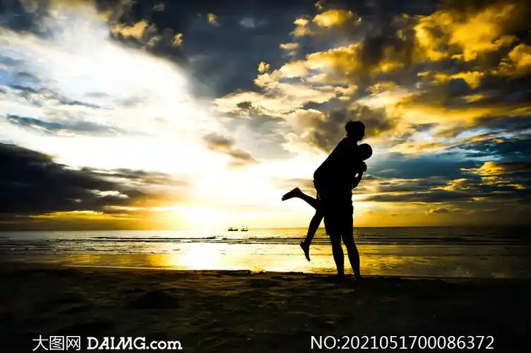 傍晚下海边拥抱的情侣剪影摄影图片