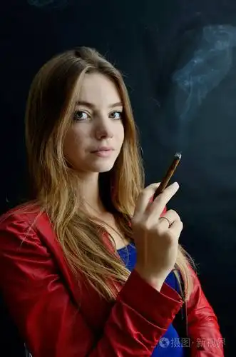 照片 年轻的女性坐在她的手 cigarillo.穿红夹克的女人喜欢抽烟.jpg