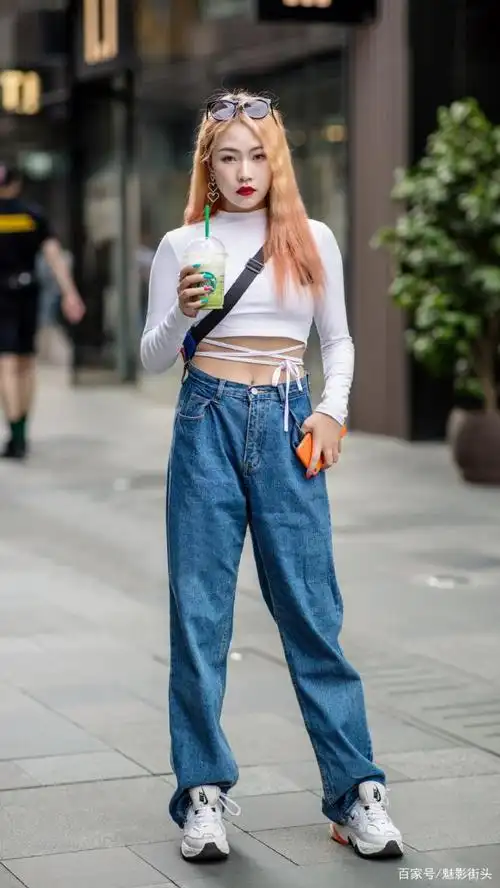 炎热的夏季,美女用宽松的牛仔裤配小白鞋,搭配出清凉的效果