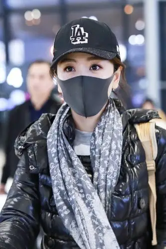 杨蓉穿黑色羽绒服现身机场,戴黑色棒球帽和口罩遮捂严实