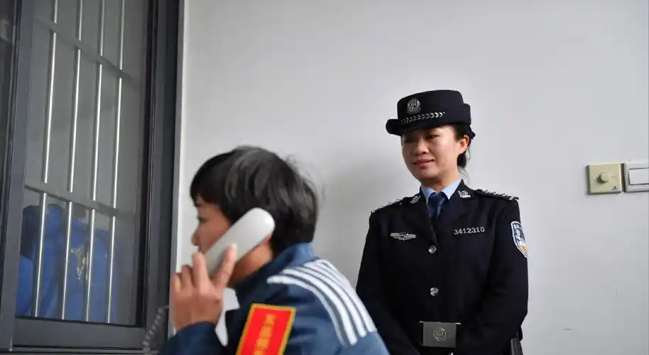 女犯人在狱警监护下打电话