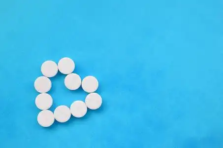 医院专题素材一些白色的药片躺在一个明亮的蓝色背景上, 形状的心脏.
