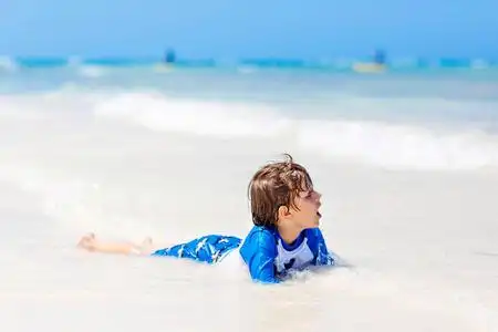 手蓝色的水背景孤立无缝模式的游泳的人和冲浪狗在冲浪板上绘制的矢量