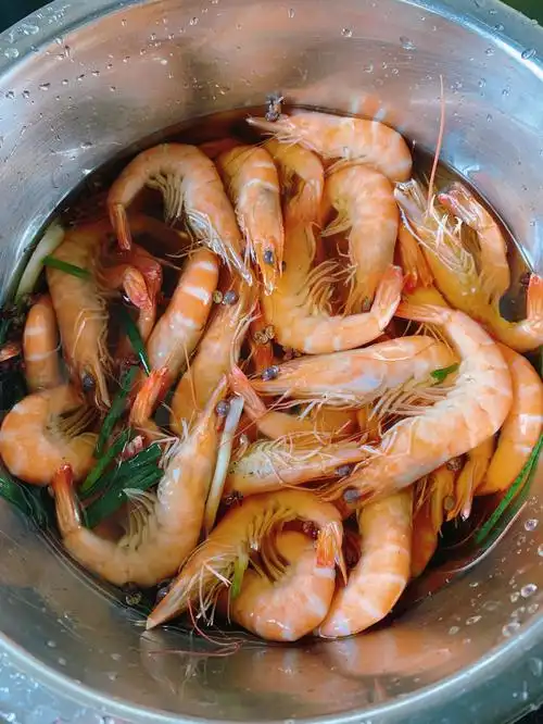 78一斤基围虾洗净,锅中烧水加葱段姜片,水开倒入虾煮两分钟,想要嫩