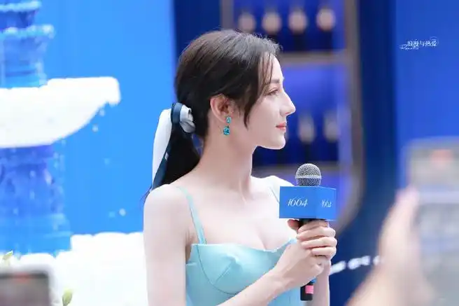 迪丽热巴今日现身1664品牌深圳活动现场,一身蓝色抹胸长裙搭配金色
