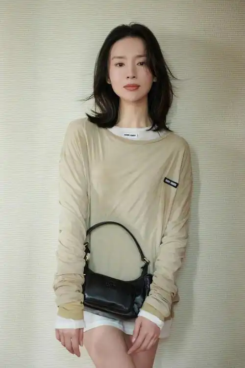 这组照片中,董洁身穿一件黑色的衬衫,搭配一条白色的长裤,整个人看