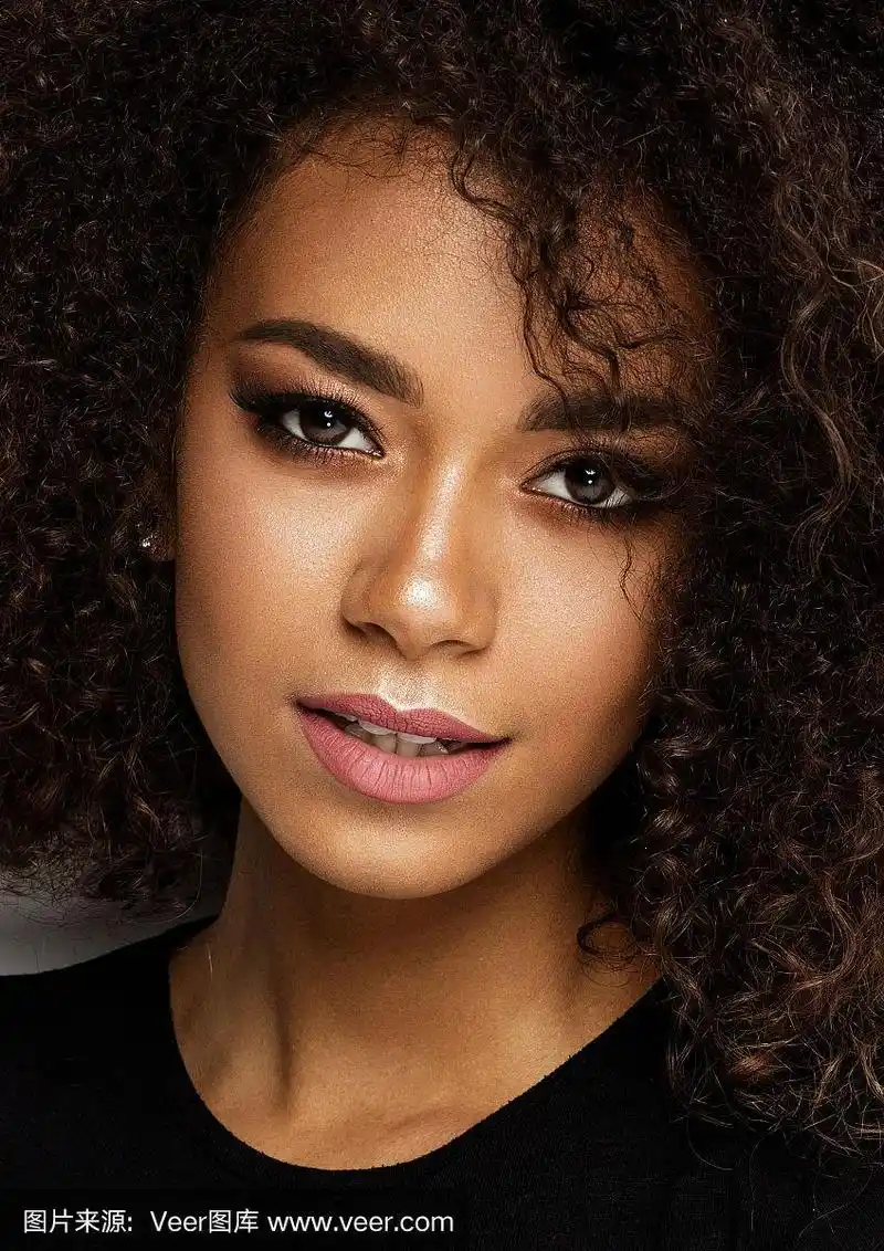 特写年轻的黑白混血女子与非洲发型和时尚的化妆