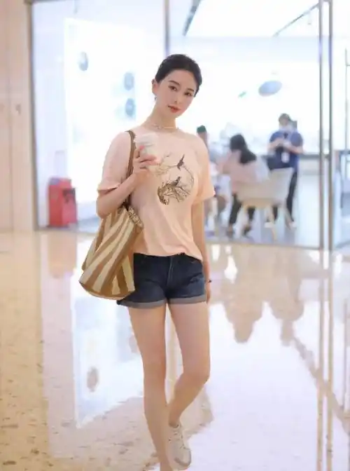 左小青在穿搭这件宽松t恤时,巧妙地将t恤下摆 "半塞"入裤装中,不仅