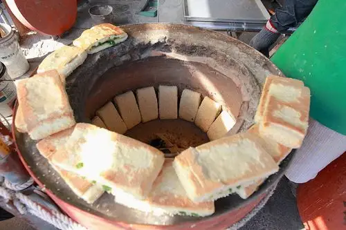 这朝牌饼外观很大一块,与胡椒饼制作方式都是ㄧ样,直接把烧饼黏在烤炉