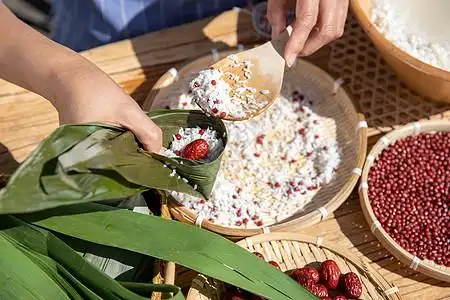 端午节户外奶奶包粽子特写图片