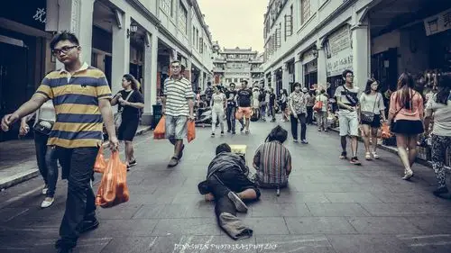 行人从乞讨者身边匆匆走过
