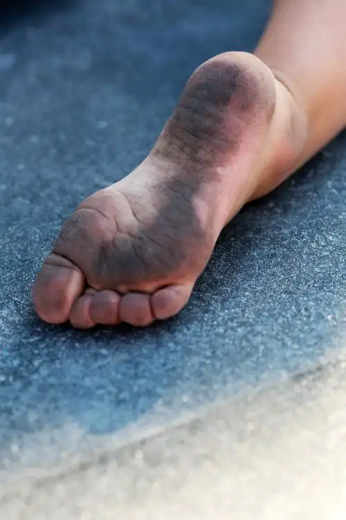 肮脏的孩子的脚在地板上