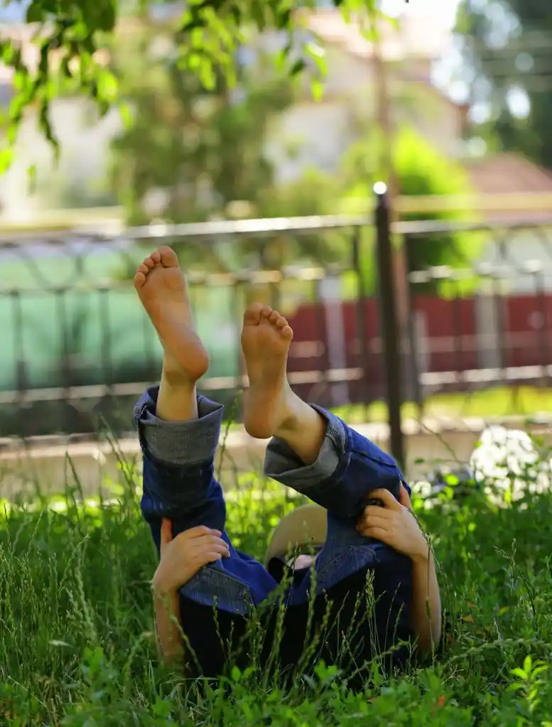 小儿童男孩躺在绿色的草坪草上