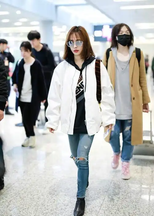 蔡依林穿白色外套搭配蓝色破洞牛仔裤现身机场戴墨镜皮肤白皙