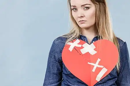 蓝色消极悲伤的轻女人,心碎的心用纸的消极悲伤情绪,关系问题射蓝色上