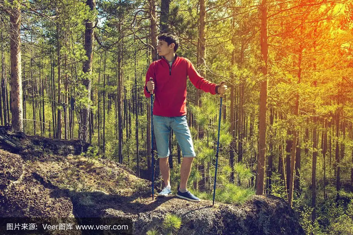 一个年轻人在森林里散步.